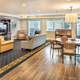 A spacious and well-lit living room with a dining area, showcasing modern furniture and cozy decor.