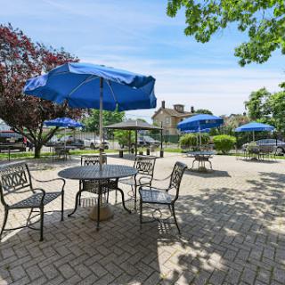 A sunny outdoor seating area with blue umbrellas, perfect for enjoying a meal or drink.