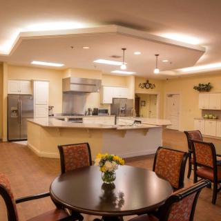 A cozy and modern kitchen with a round dining table, elegant lighting, and ample space for cooking.