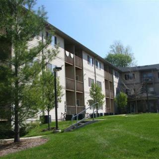 A view of a residential apartment building surrounded by greenery and trees.