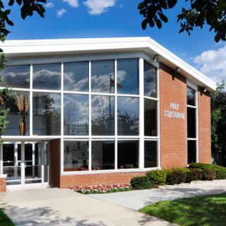 A modern library building with large glass windows and a brick exterior.