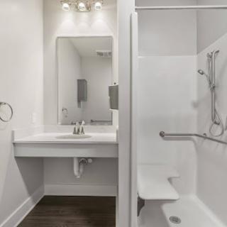 A modern bathroom featuring a sleek sink and shower area.