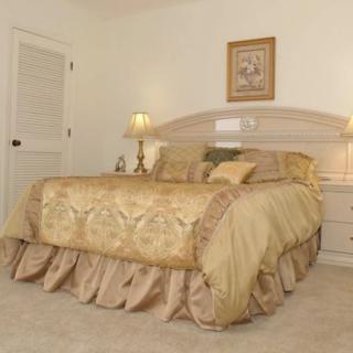 A cozy bedroom with a neatly made bed, elegant decor, and soft lighting.