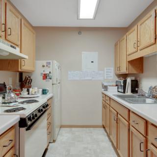 A traditional kitchen setup with wooden cabinets and essential appliances.