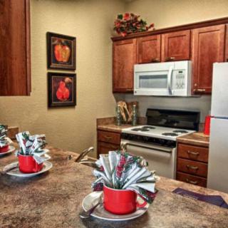 A cozy kitchen with wooden cabinets, a dining area setup, and modern appliances.