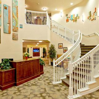 An elegant hotel lobby featuring a grand staircase and welcoming reception area.