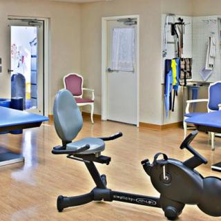 A gym with various exercise equipment in a well-lit room.