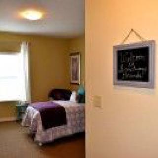 A cozy bedroom with warm lighting and a chalkboard on the wall.