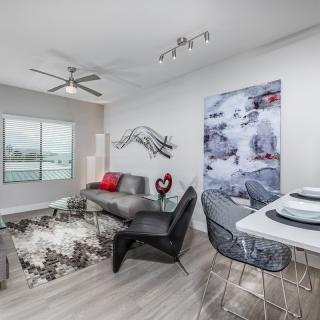 A modern living room with contemporary furniture and minimalist decor, featuring a stylish dining area and accent wall art.