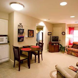 A cozy apartment living room and dining area with warm lighting and comfortable furniture.