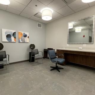A modern salon interior with chairs, a mirror, and hair dryers.