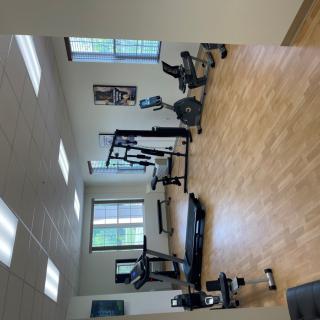 A well-lit gym with various exercise machines and equipment.