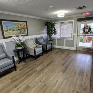 A welcoming waiting area featuring comfortable chairs, decorative plants, and artwork.