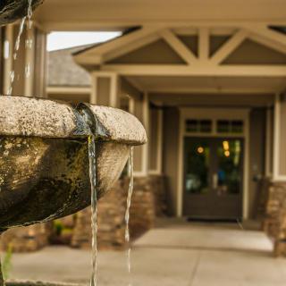 A close-up of a flowing fountain in front of a building entrance.
