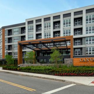 Modern apartment building with a contemporary design and landscaped entrance.