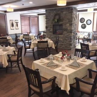 An elegant restaurant dining room with neatly set tables and comfortable chairs.