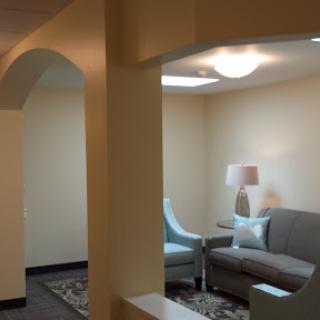 A cozy lounge area featuring a gray sofa and a stylish lamp.