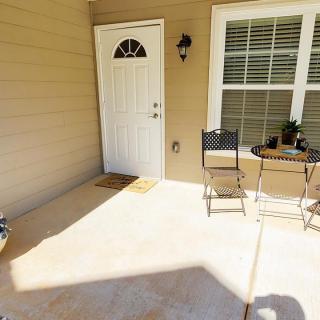 Sunny front porch with a small table and chairs.