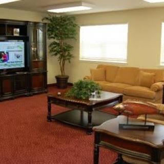 A cozy living room with a sofa, coffee table, television, and an indoor plant.