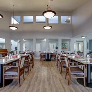 A spacious and modern dining room with neatly arranged tables and elegant lighting.
