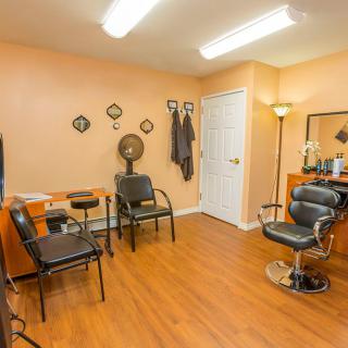 Interior of a salon with chairs, mirrors, and hairdressing equipment.