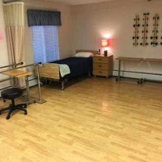 A simple, clean patient room equipped with essential furniture.