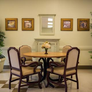 A cozy dining area with a round table and four chairs, adorned with decorative artwork on the walls.