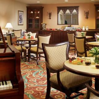 A cozy restaurant dining area with elegant furniture and a piano.