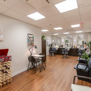 A modern nail salon interior with manicure stations and bright lighting.