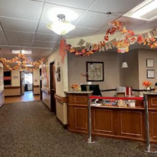 A warmly decorated office reception area with autumn-themed decorations.