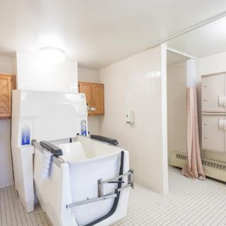 A spacious and accessible bathroom featuring a bathtub and a shower area.