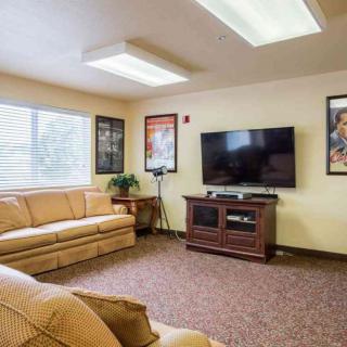 A cozy living room featuring a sofa, television, and framed posters on the wall.