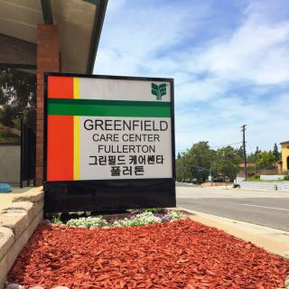Sign for Greenfield Care Center Fullerton on a sunny day.