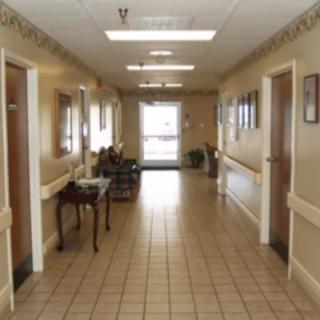 A well-lit hallway with tiled floors and multiple doors on each side.