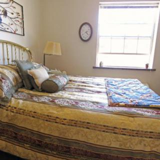 Cozy bedroom with patterned bedding and natural light.