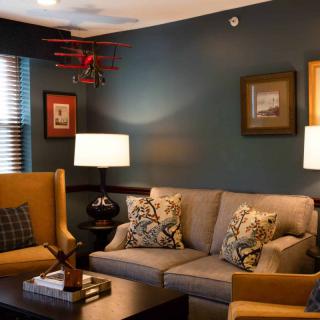 A cozy living room with a sofa, armchairs, and warm lighting.