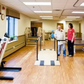 A physical therapy room with a therapist assisting a patient during a rehabilitation session.