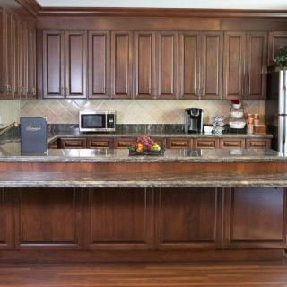 A modern kitchen with wooden cabinets and various appliances on the countertop.
