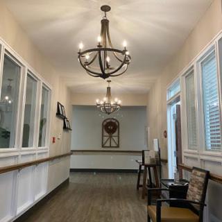 A well-lit hallway with chandeliers and comfortable seating.