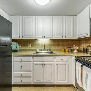 A modern kitchen with white cabinets and stainless steel appliances.
