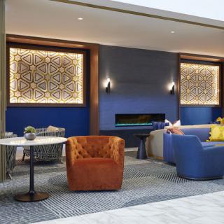 A stylish and modern living room with colorful seating and intricate wall designs.