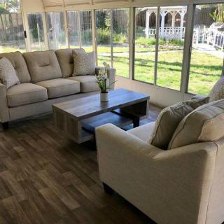 Bright sunroom with comfortable seating and a coffee table overlooking the garden.