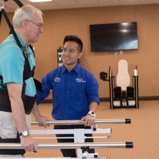 A physical therapist assists a patient during rehabilitation exercises in a modern fitness facility.