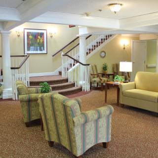A cozy lobby with comfortable seating and a staircase leading to an upper floor.