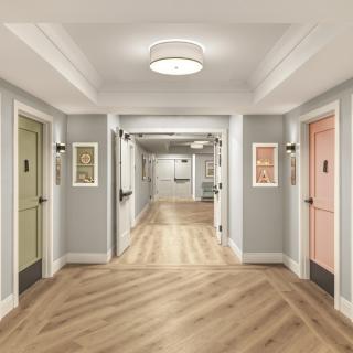 A well-lit hallway with colorful doors and wood flooring.
