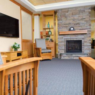 A cozy living room with a stone fireplace and modern wooden furniture.