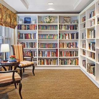 A cozy library corner with bookshelves filled with a variety of books and comfortable seating.