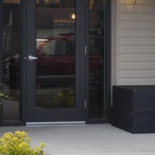 Front door entrance of a house with steps and plants.