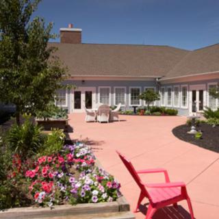 A sunny courtyard with blooming flowers and outdoor seating.