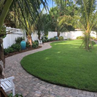 A tranquil garden with a curved brick pathway and lush greenery.